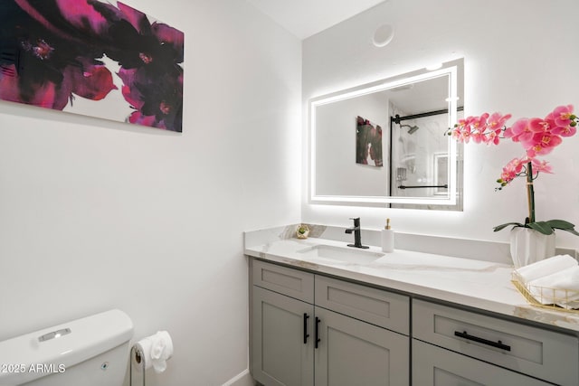 bathroom featuring vanity, a shower stall, and toilet