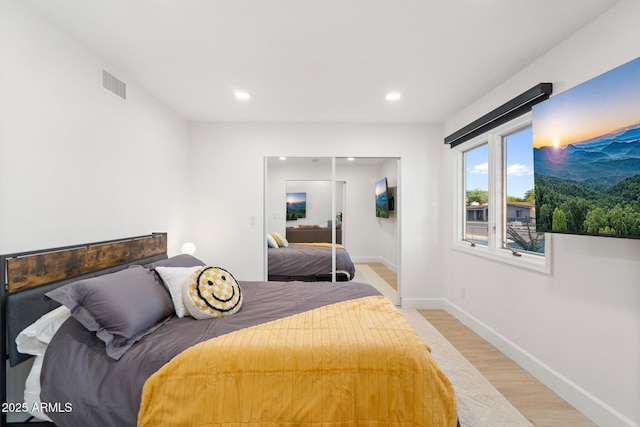 bedroom with light wood-style floors, a closet, recessed lighting, and visible vents