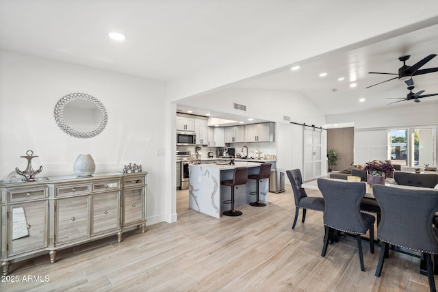 dining room featuring recessed lighting, ceiling fan, visible vents, and a barn door