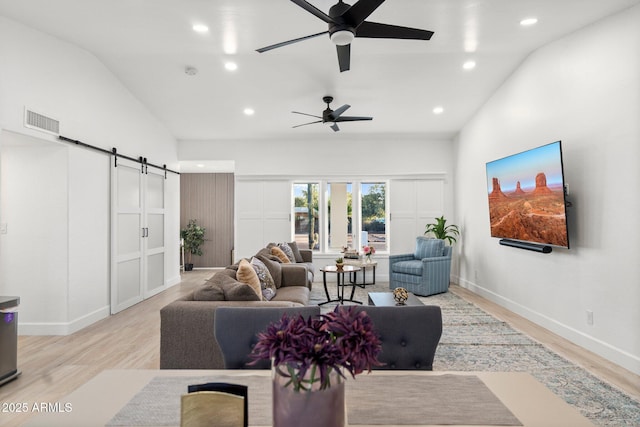 living area with a barn door, light wood-style floors, recessed lighting, a ceiling fan, and visible vents