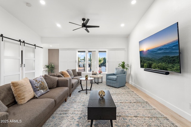 living area with a barn door, light wood finished floors, a ceiling fan, baseboards, and recessed lighting