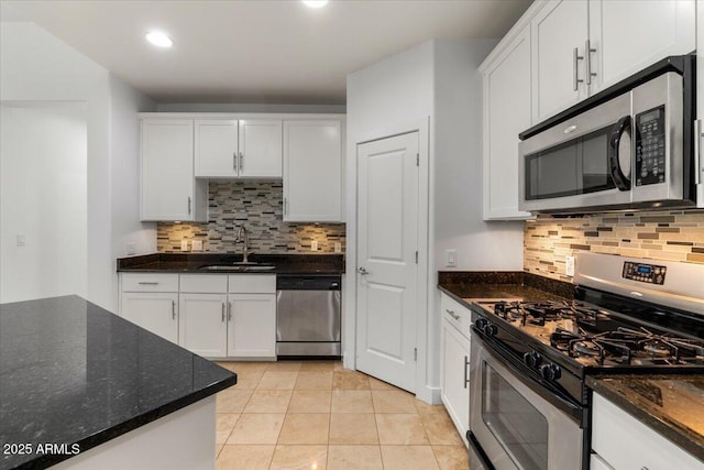 945 E Playa Del Norte Dr Unit 1016, Tempe, AZ 85288 - kitchen featuring appliances with stainless steel finishes, backsplash, white cabinets, light tile patterned flooring, and dark stone countertops