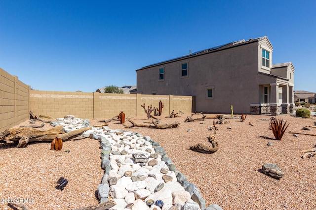 back of property with stucco siding and fence