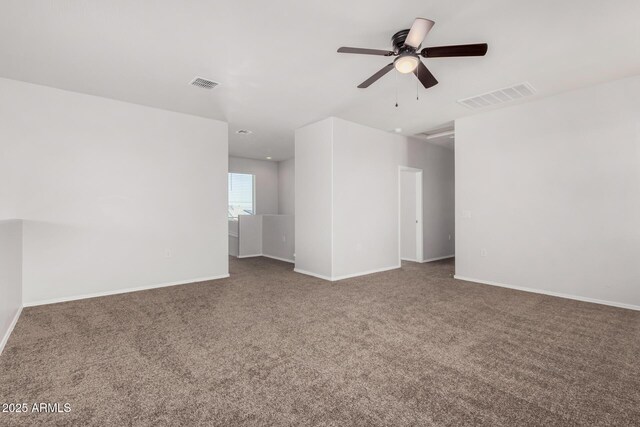 carpeted empty room featuring visible vents, a ceiling fan, and baseboards