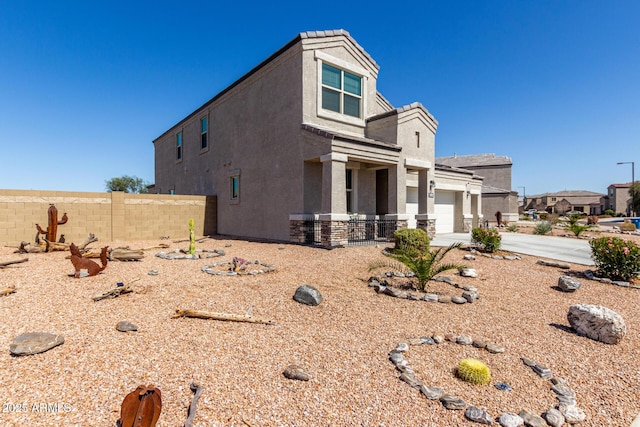 view of home's exterior featuring fence, driveway, and stucco siding