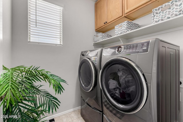 washroom featuring light tile patterned floors, baseboards, separate washer and dryer, and cabinet space