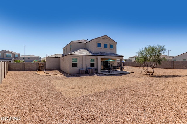 rear view of house with a patio area, cooling unit, and a fenced backyard