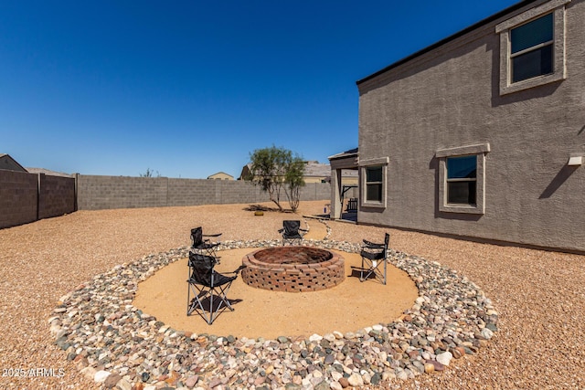 view of yard featuring a patio area, a fenced backyard, and an outdoor fire pit