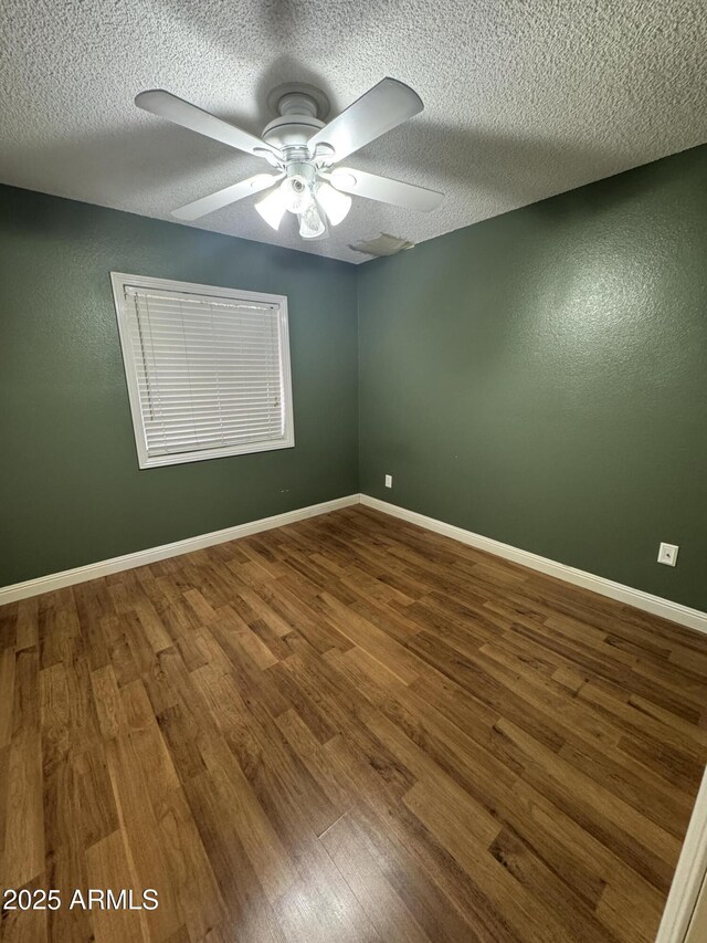 11221 N 91st Dr, Peoria, AZ 85345 - spare room with wood finished floors, a textured ceiling, ceiling fan, and baseboards