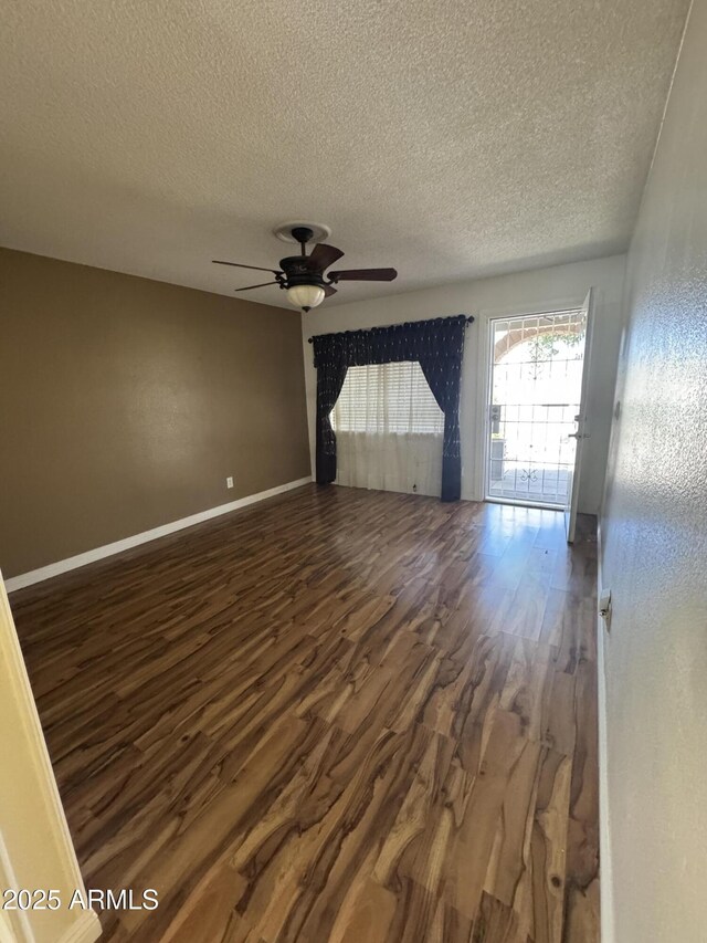 11221 N 91st Dr, Peoria, AZ 85345 - empty room featuring a textured ceiling, dark wood finished floors, a ceiling fan, and baseboards