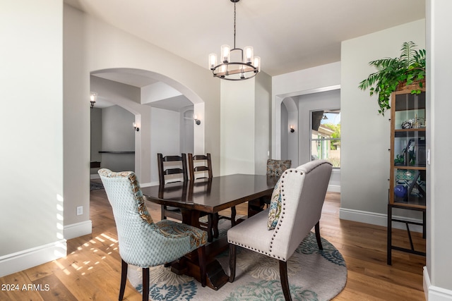 dining space featuring light hardwood / wood-style floors and a chandelier