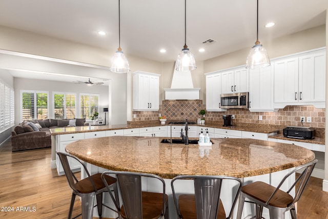 kitchen with hardwood / wood-style flooring, ceiling fan, hanging light fixtures, and sink