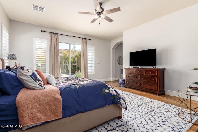 bedroom with access to outside, light hardwood / wood-style flooring, and ceiling fan