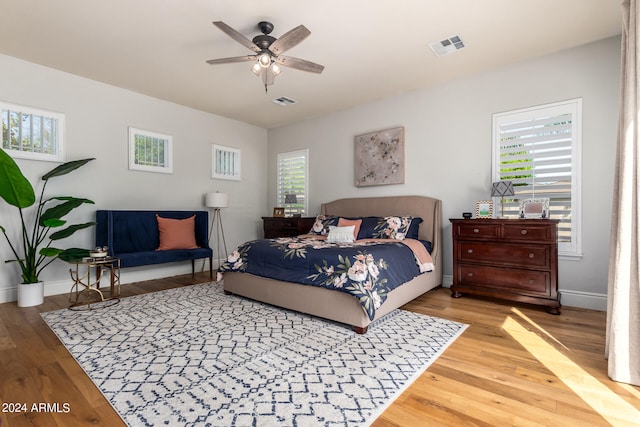 bedroom with multiple windows, ceiling fan, and light hardwood / wood-style floors