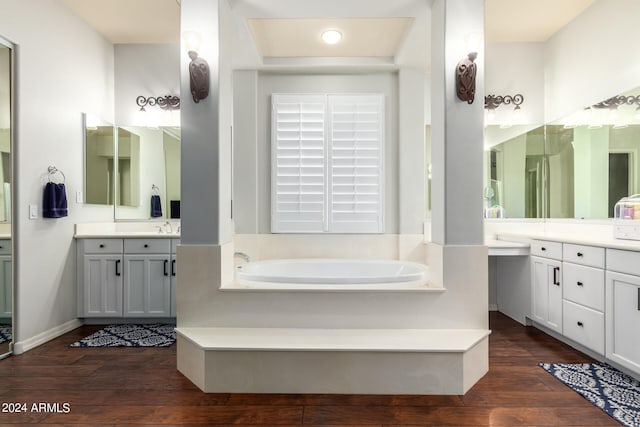 bathroom with a bathtub, vanity, and wood-type flooring