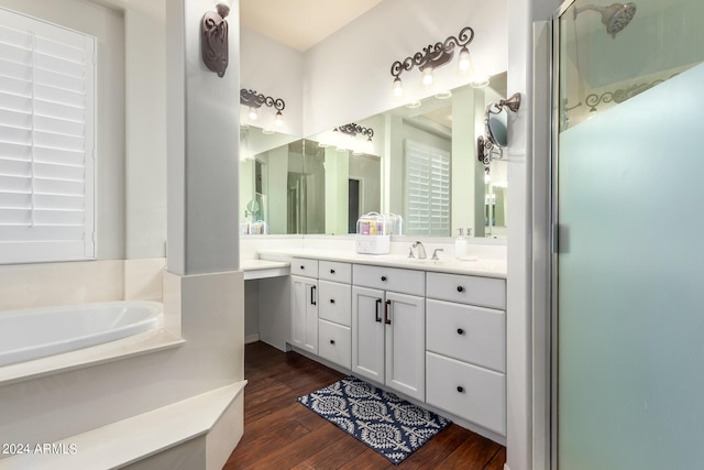 bathroom featuring wood-type flooring, shower with separate bathtub, and vanity