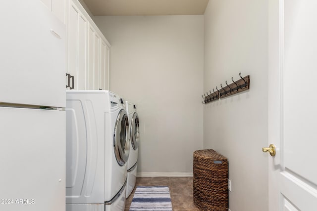 laundry area featuring washer and clothes dryer, cabinets, and tile patterned floors