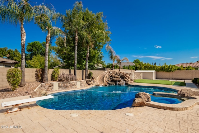 view of swimming pool with an in ground hot tub, pool water feature, a diving board, and a patio area