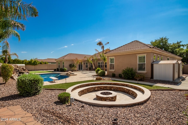 view of pool featuring a patio area, a fire pit, and a storage unit