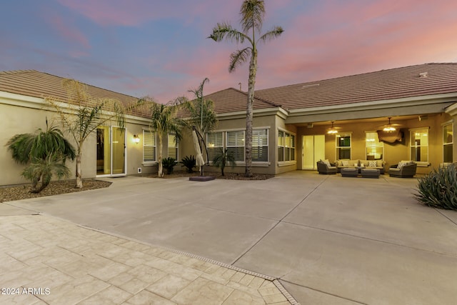 back house at dusk with an outdoor hangout area and a patio area