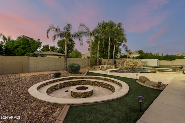 yard at dusk featuring a fire pit