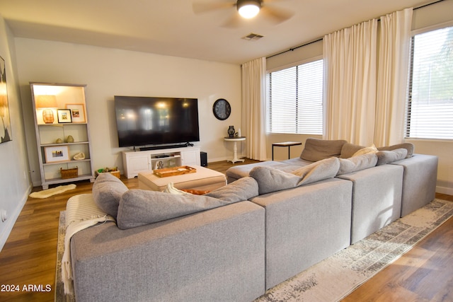 living room featuring ceiling fan and dark wood-type flooring