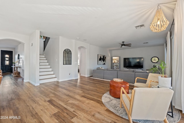 2811 E Riviera Pl, Chandler, AZ 85249 - living area featuring arched walkways, stairs, wood finished floors, and ceiling fan