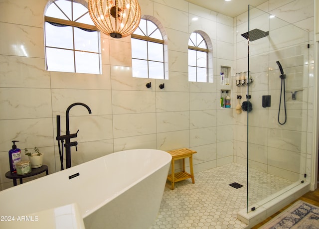 bathroom with separate shower and tub, tile patterned floors, and tile walls