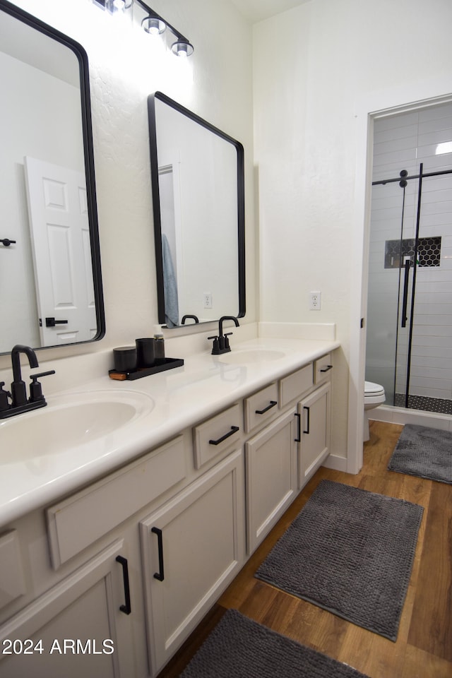 bathroom featuring vanity, toilet, an enclosed shower, and wood-type flooring