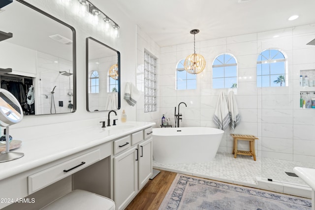 2811 E Riviera Pl, Chandler, AZ 85249 - bathroom featuring a soaking tub, wood finished floors, vanity, tiled shower, and tile walls
