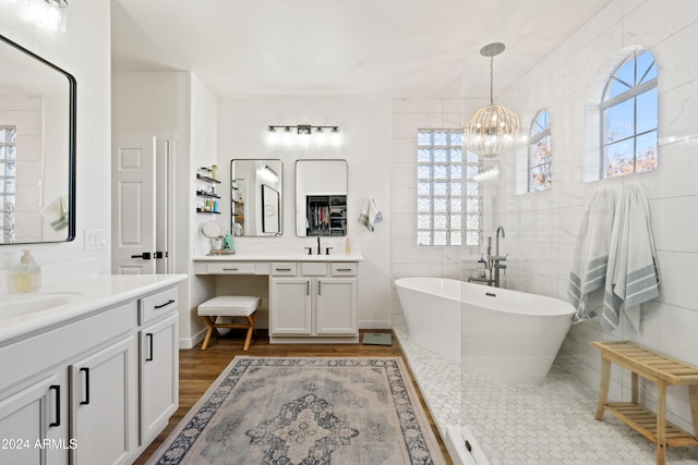 2811 E Riviera Pl, Chandler, AZ 85249 - bathroom with a soaking tub, two vanities, a chandelier, wood finished floors, and tile walls