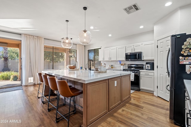 2811 E Riviera Pl, Chandler, AZ 85249 - kitchen featuring stainless steel appliances, a kitchen bar, backsplash, light wood finished floors, and recessed lighting