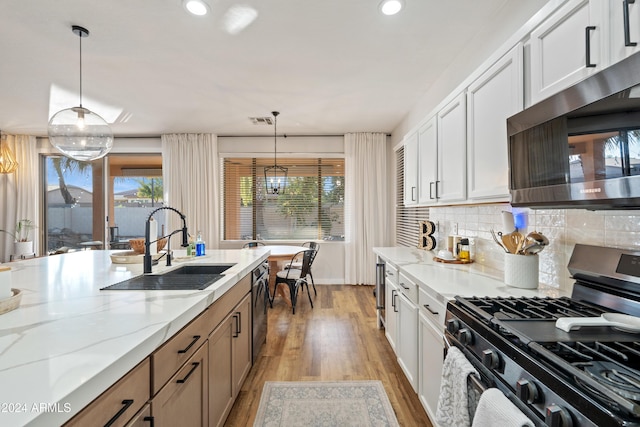 2811 E Riviera Pl, Chandler, AZ 85249 - kitchen featuring appliances with stainless steel finishes, a sink, light wood finished floors, healthy amount of natural light, and recessed lighting