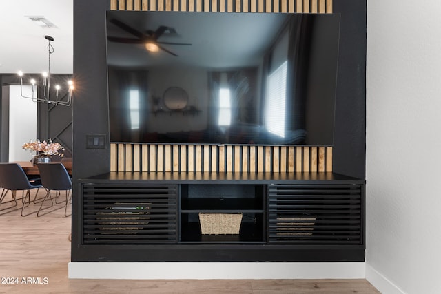 room details with hardwood / wood-style flooring and ceiling fan with notable chandelier