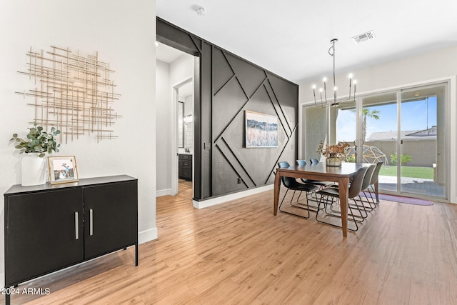 dining room featuring light hardwood / wood-style flooring and a notable chandelier