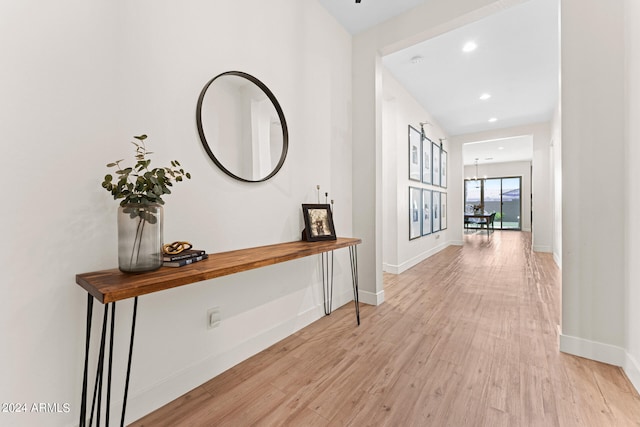 hall featuring a notable chandelier and light wood-type flooring