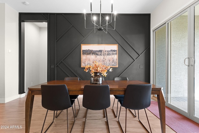 dining room with light wood-type flooring, plenty of natural light, and a chandelier