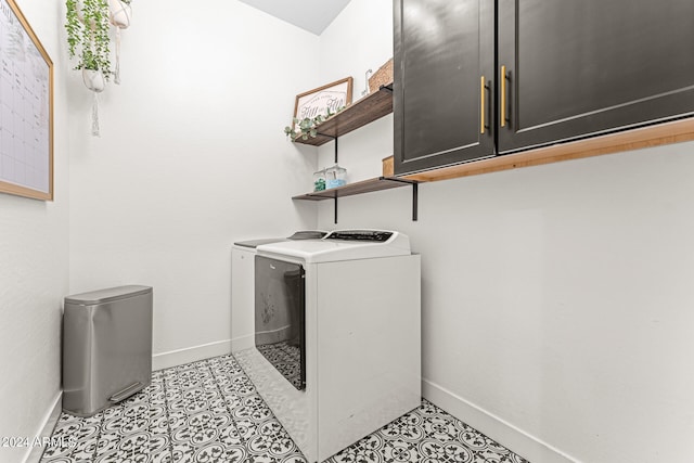 washroom featuring cabinets and washer and clothes dryer