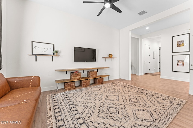 living room with wood-type flooring and ceiling fan