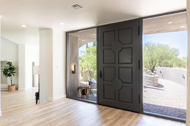 foyer with recessed lighting, light wood-type flooring, baseboards, floor to ceiling windows, and visible vents