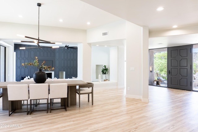 kitchen featuring pendant lighting, a chandelier, a kitchen bar, and light hardwood / wood-style floors