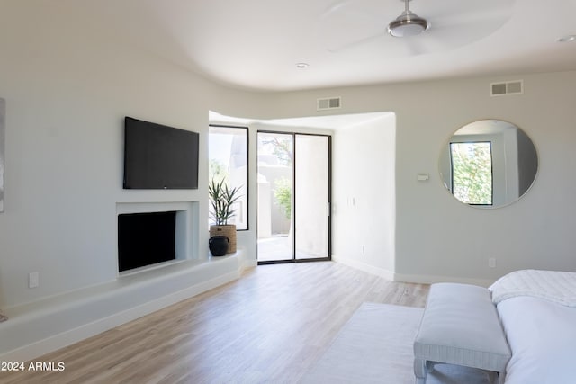 living area featuring baseboards, visible vents, a ceiling fan, and wood finished floors