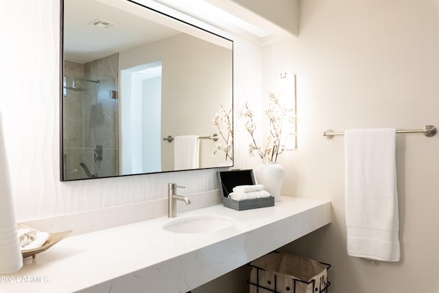 bathroom featuring a shower with door and vanity