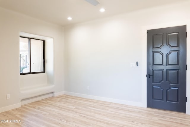 spare room with baseboards, light wood-type flooring, and recessed lighting