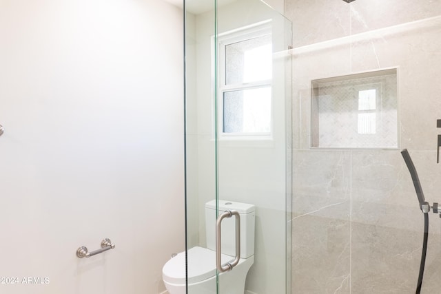 bathroom featuring toilet and a stall shower
