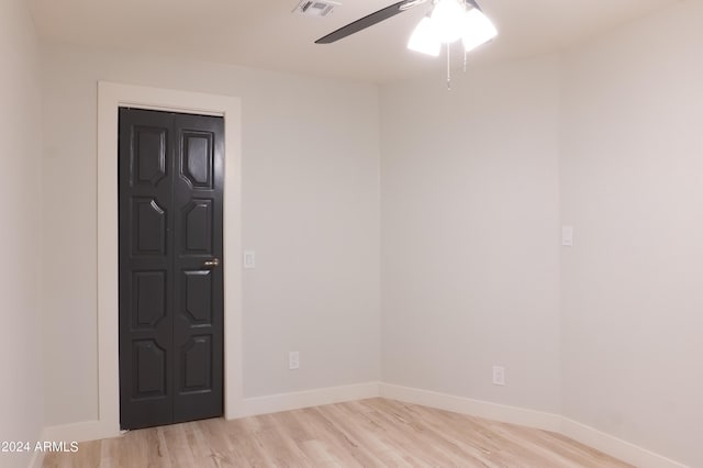 spare room featuring baseboards, visible vents, light wood-style floors, and a ceiling fan