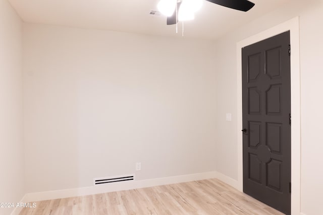 spare room with ceiling fan, a baseboard radiator, and light hardwood / wood-style floors