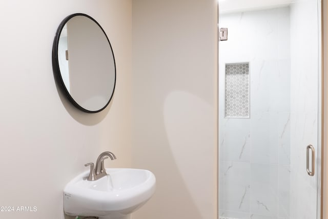 bathroom with sink and a tile shower