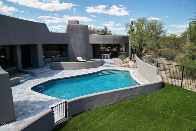 view of swimming pool with a yard and a patio