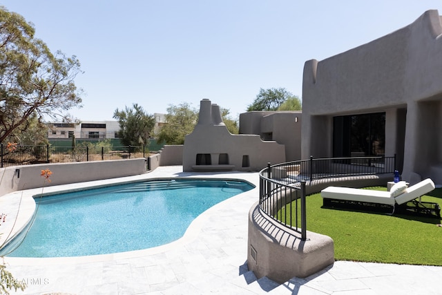 view of swimming pool featuring a patio area and a fireplace